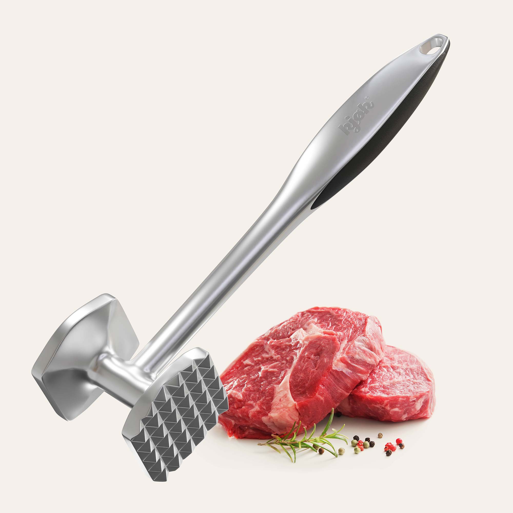 Fleischklopfer mit rohem Stück Fleisch und Gewürzen im Hintergrund