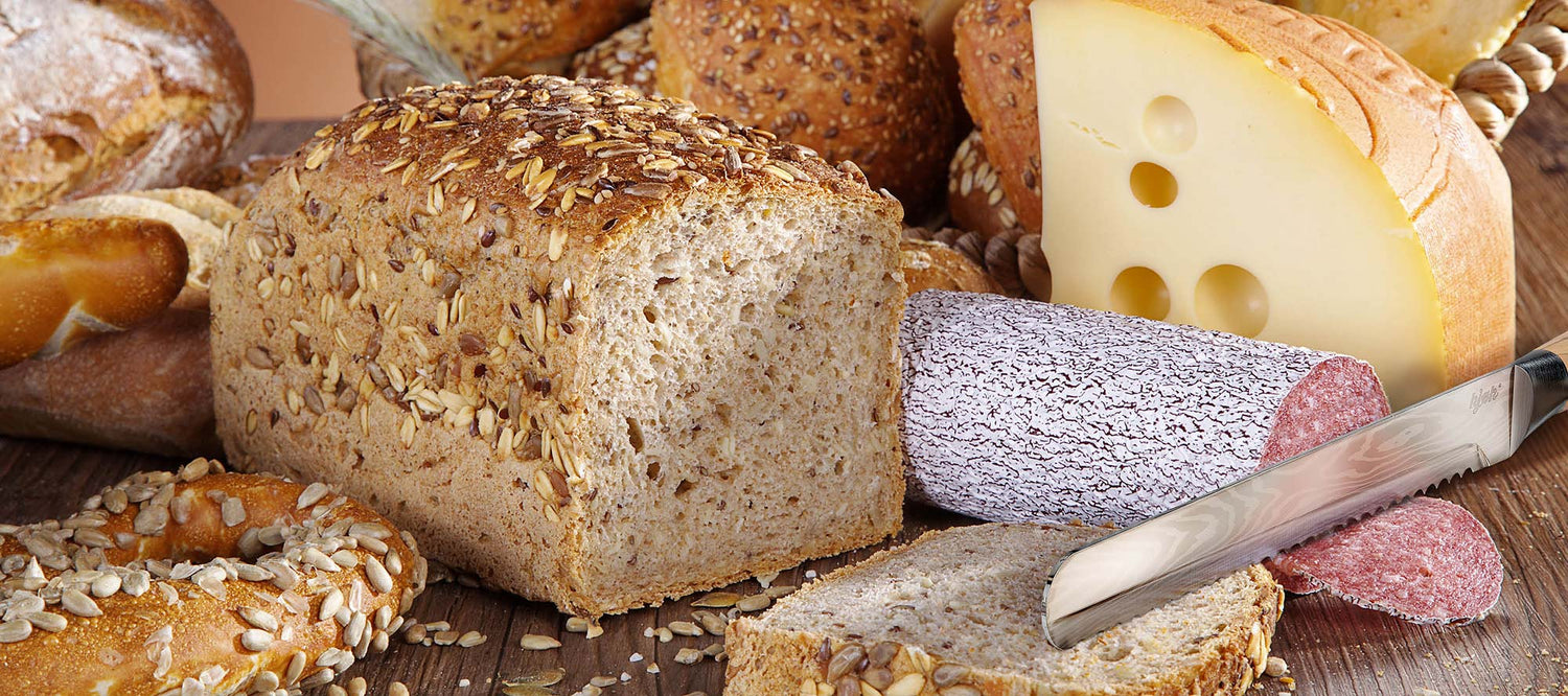 Rustikales Brotmesser mit Holzgriff in Frühstücksszene mit Körnerbrot