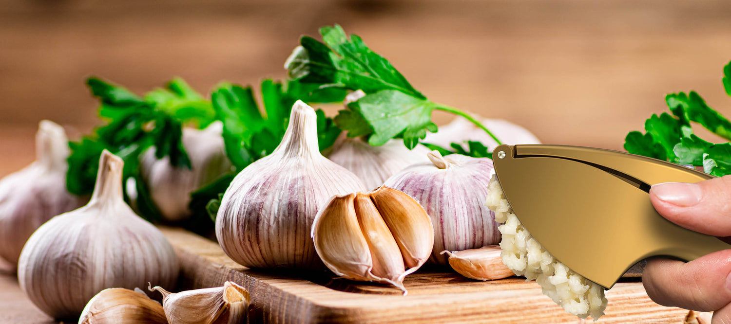 Goldene Knoblauchpresse mit frischem Knoblauch und Petersilie auf Holzbrett, elegantes Küchenzubehör für müheloses Kochen