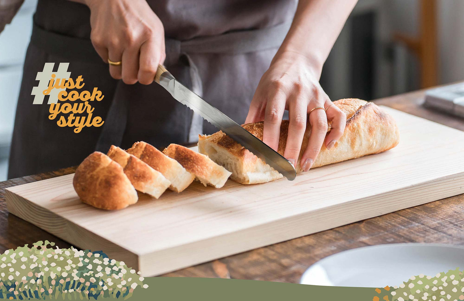 Brotmesser mit Wellenschliff schneidet frisches Baguette auf Holzbrett